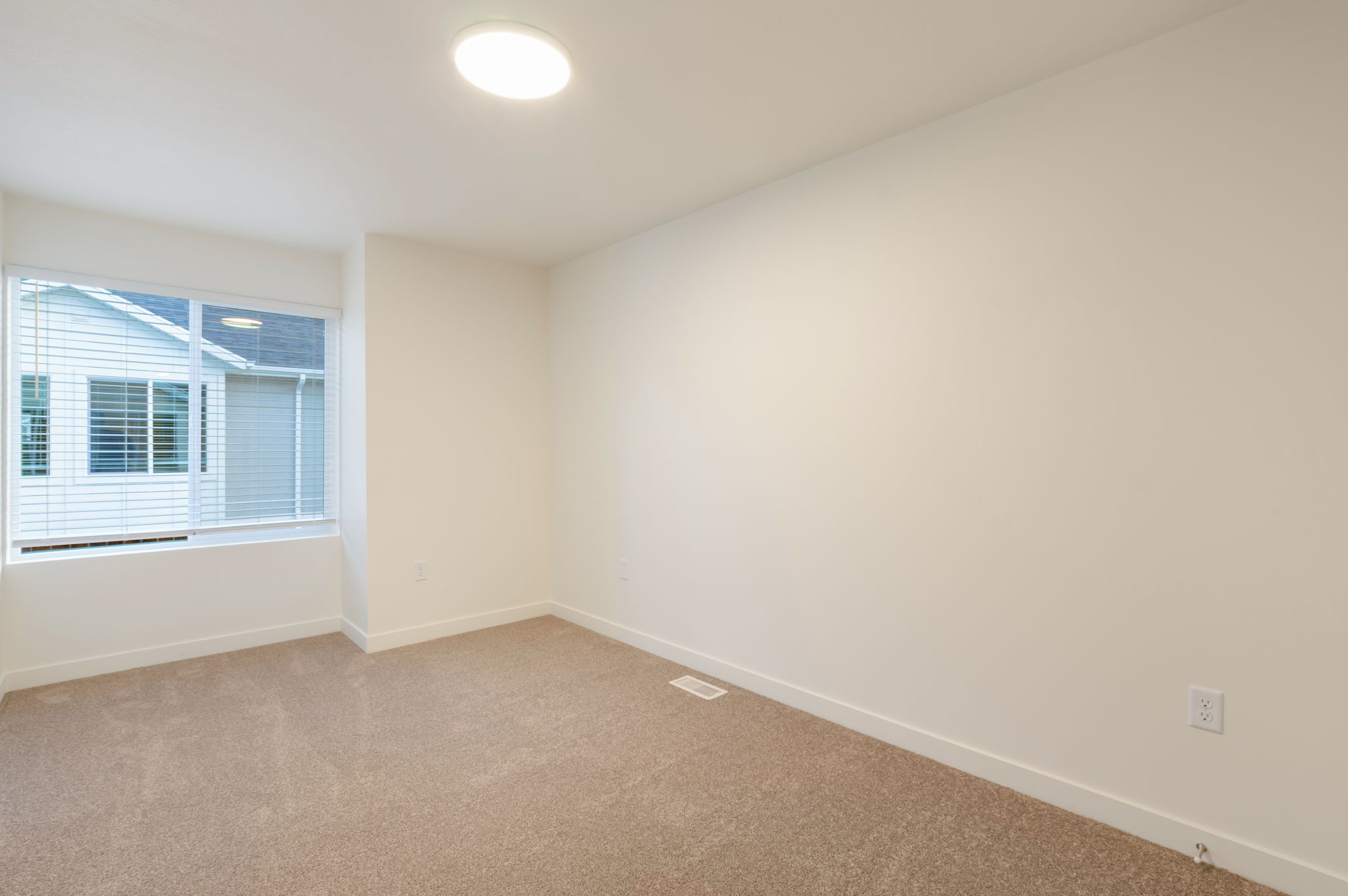 Unfurnished room with baseboards and light colored carpet