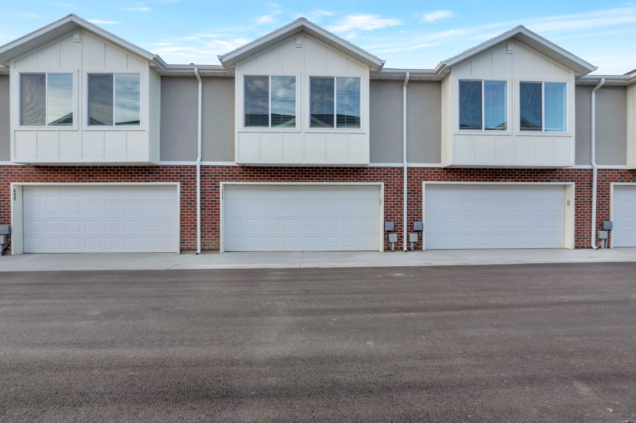 View of front of property featuring board and batten siding, an attached garage, and driveway