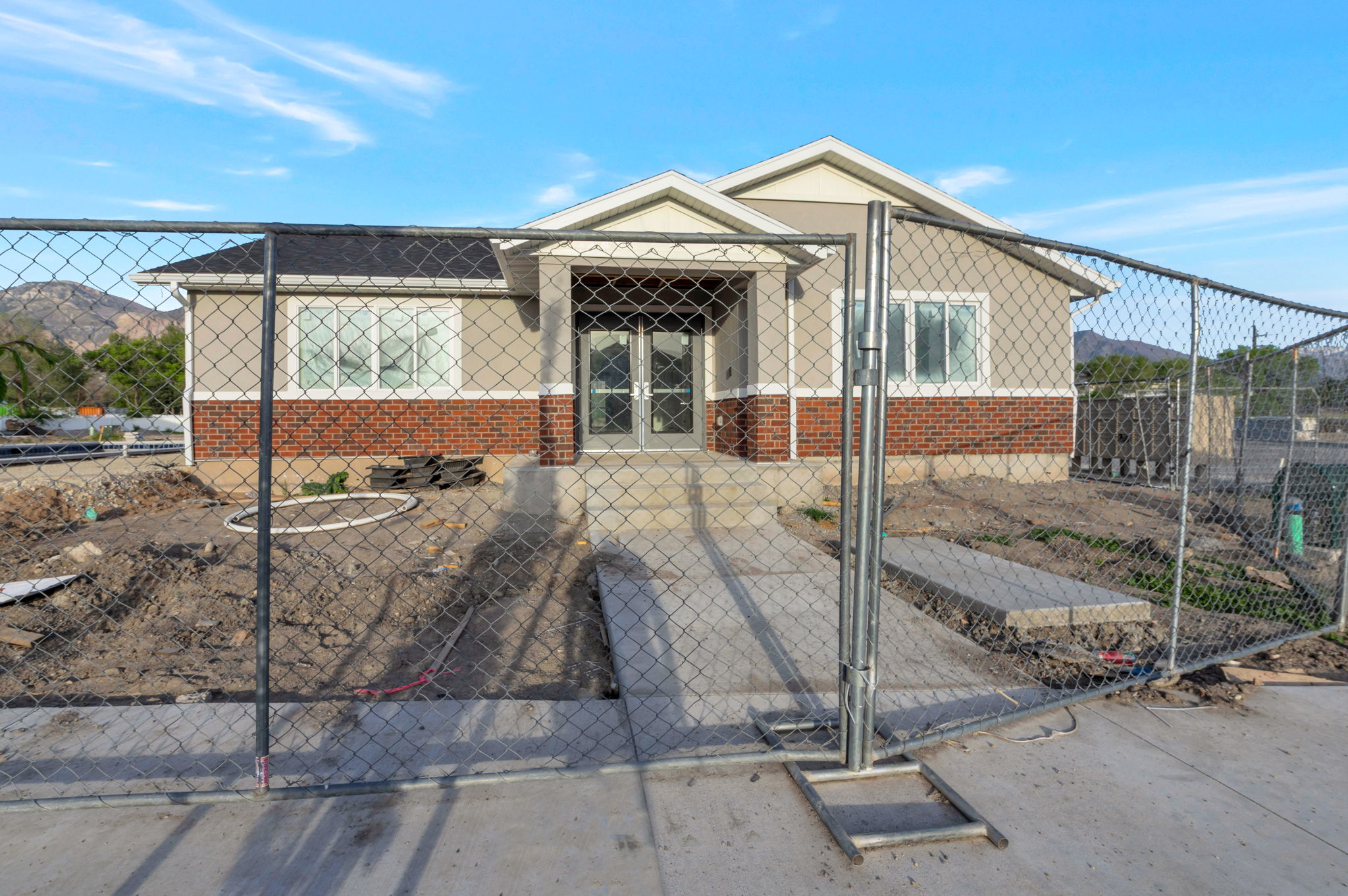 View of front of home featuring a fenced front yard, a mountain view, a gate, and brick siding