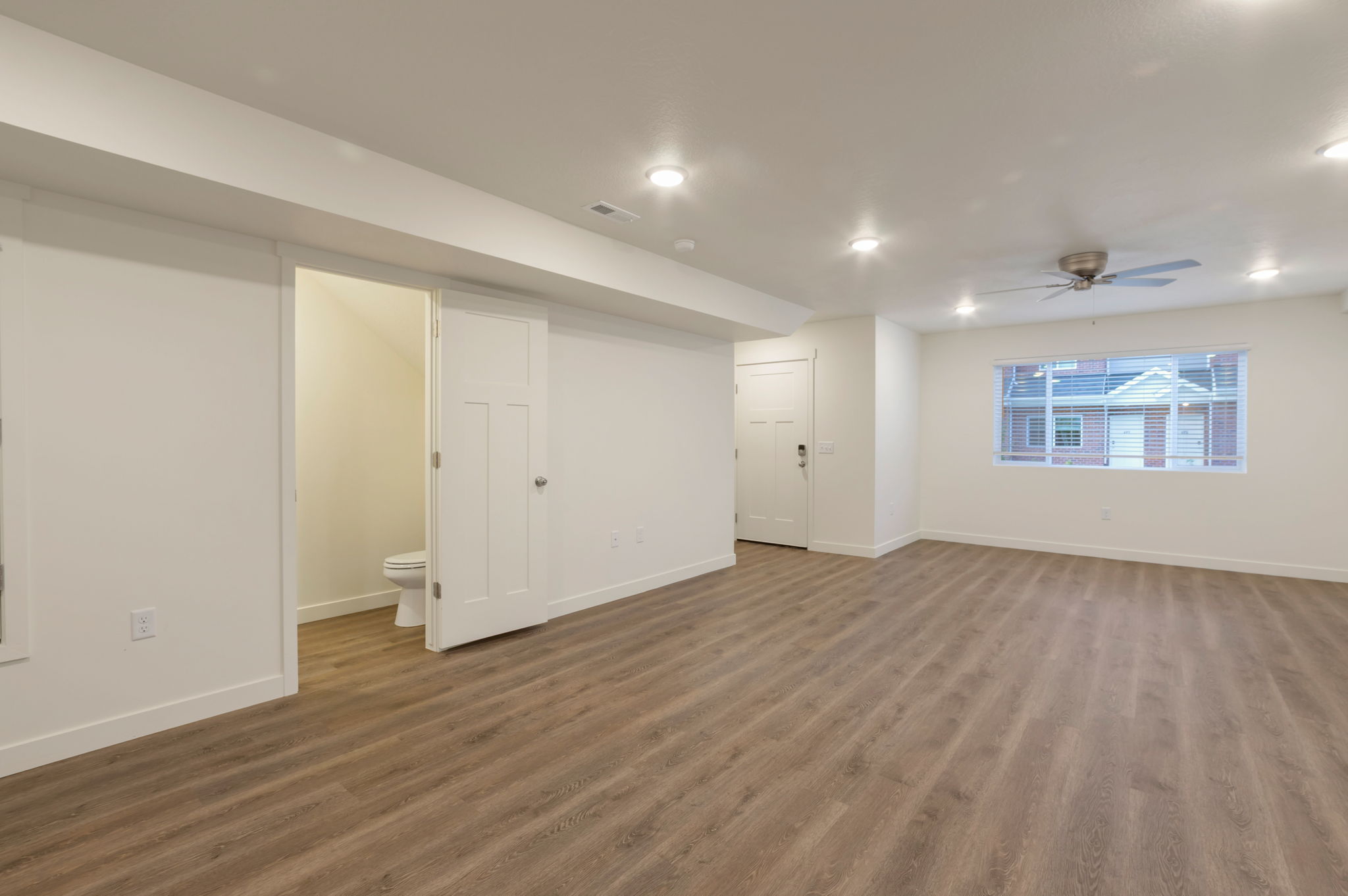 Basement featuring dark wood-type flooring, ceiling fan, and recessed lighting