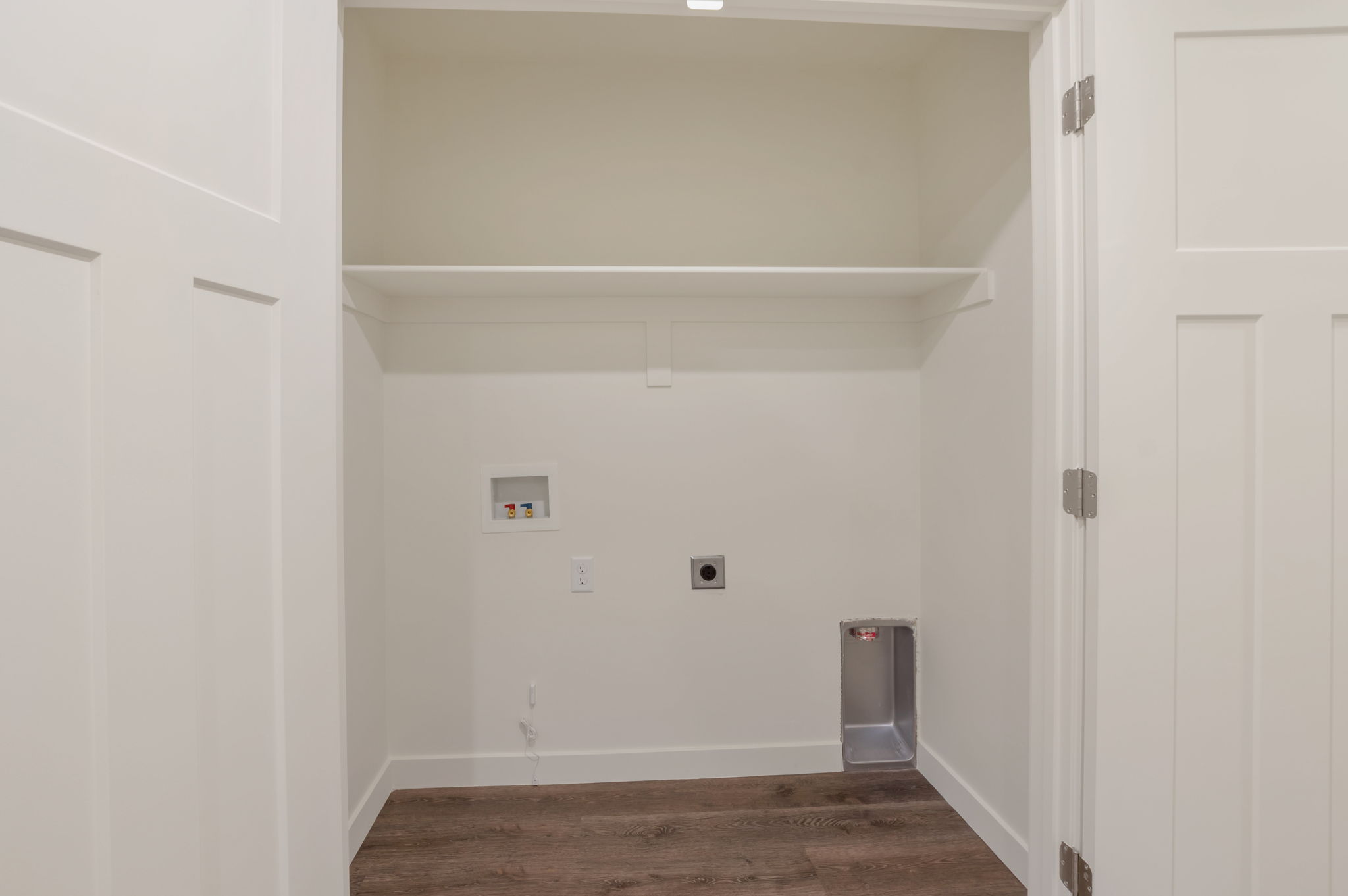 Laundry area with dark wood finished floors, electric dryer hookup, and washer hookup