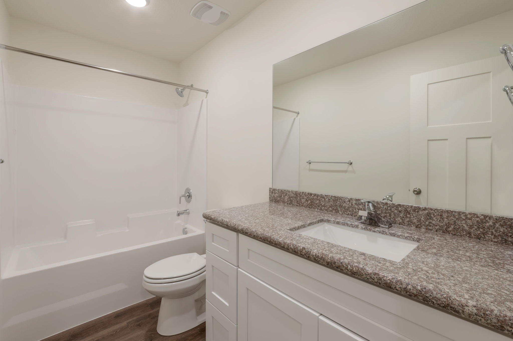 Bathroom with vanity, shower / tub combination, and dark wood-type flooring