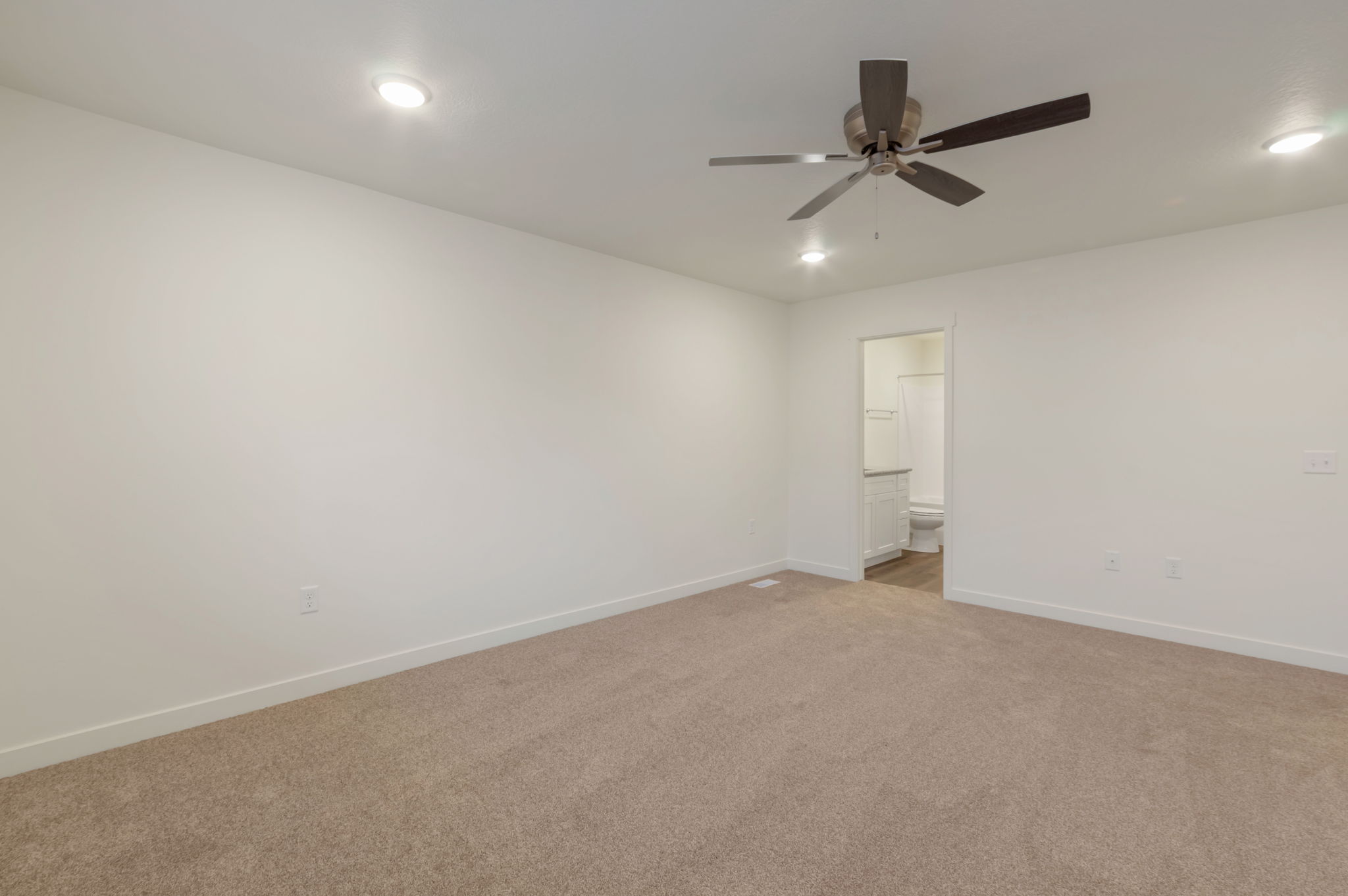 Unfurnished bedroom featuring carpet, ensuite bathroom, recessed lighting, and ceiling fan