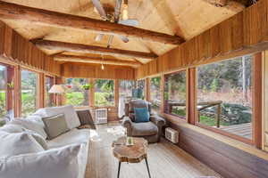 Sunroom with wood-type flooring and lofted ceiling with beams
