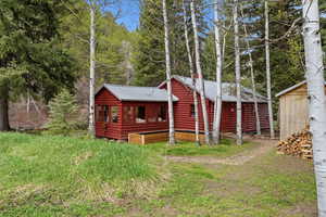 View of front of home with log veneer siding and a metal roof