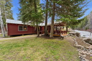 Back of house featuring a deck, a metal roof, and a yard