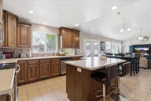 Kitchen featuring stainless steel appliances, backsplash, open floor plan, a kitchen island, and lofted ceiling
