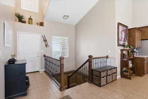 Foyer featuring light tile patterned floors and vaulted ceiling