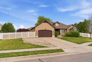 View of front facade featuring a gate, stone siding, stucco siding, an attached garage, and concrete driveway