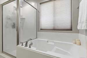 Bathroom featuring a stall shower and a garden tub