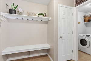Laundry room with washer / dryer and light tile patterned floors