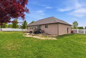 Back of property with a fenced backyard, a patio, and a gate