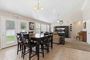 Dining area featuring vaulted ceiling, suspended lighting, ceiling fan, and light tile patterned flooring