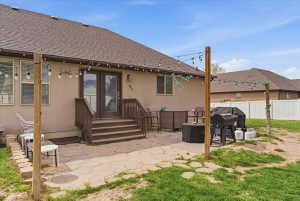Back of house with a patio, a shingled roof, and stucco siding