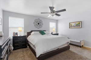 Bedroom with dark colored carpet, a textured ceiling, and a ceiling fan
