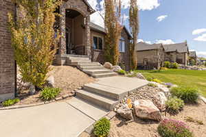 Entrance to property with brick siding and a yard