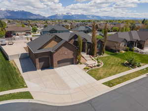 View of front of house with an attached garage, driveway, brick siding, a residential view, and a front lawn