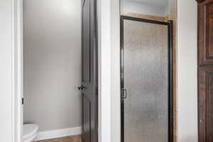 Full bathroom featuring a shower stall and toilet