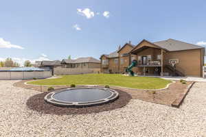 View of yard with a balcony, a residential view, a trampoline, and a playground