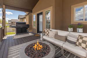 Wooden terrace with area for grilling and an outdoor fire pit