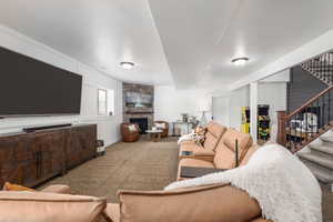 Living room with carpet flooring and a stone fireplace