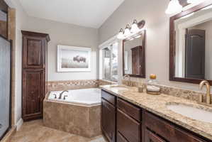 Full bathroom featuring double vanity, a bath, and a shower stall