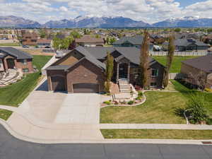 View of front of house featuring a garage, concrete driveway, brick siding, and a residential view