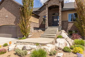 View of front facade featuring concrete driveway, brick siding, and an attached garage