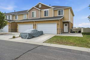 Craftsman inspired home featuring stone siding, a garage, board and batten siding, and concrete driveway