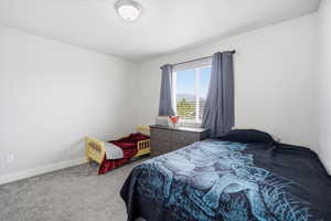 Bedroom featuring carpet and baseboards