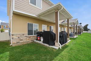 Back of property with a patio area and stone siding