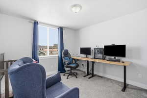 Office area featuring light carpet and baseboards