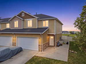 Craftsman-style home featuring stone siding, a garage, board and batten siding, concrete driveway, and a shingled roof