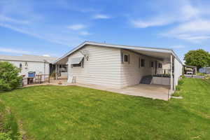 Back of house with a lawn and a patio area