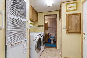 Laundry area with a heating unit, cabinet space, and independent washer and dryer