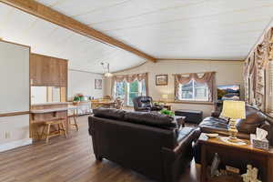 Living area with wood finished floors and beam ceiling