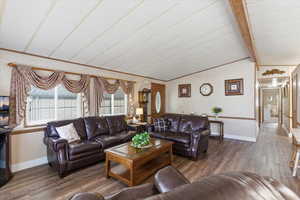 Living room with wood finished floors and lofted ceiling with beams