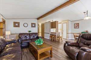 Living area featuring lofted ceiling with beams and wood finished floors