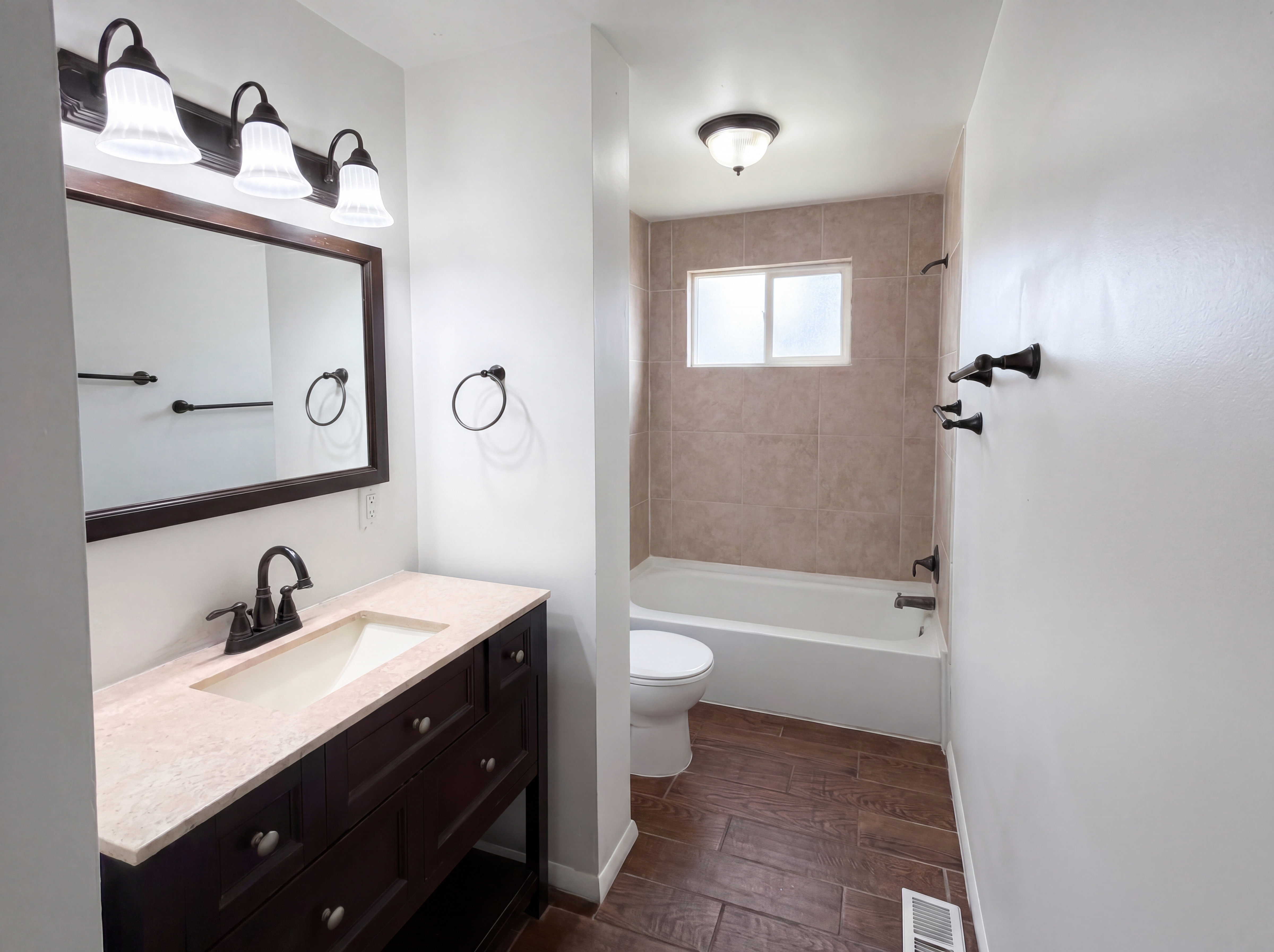 Bathroom featuring vanity, dark wood finished floors, and bathing tub / shower combination