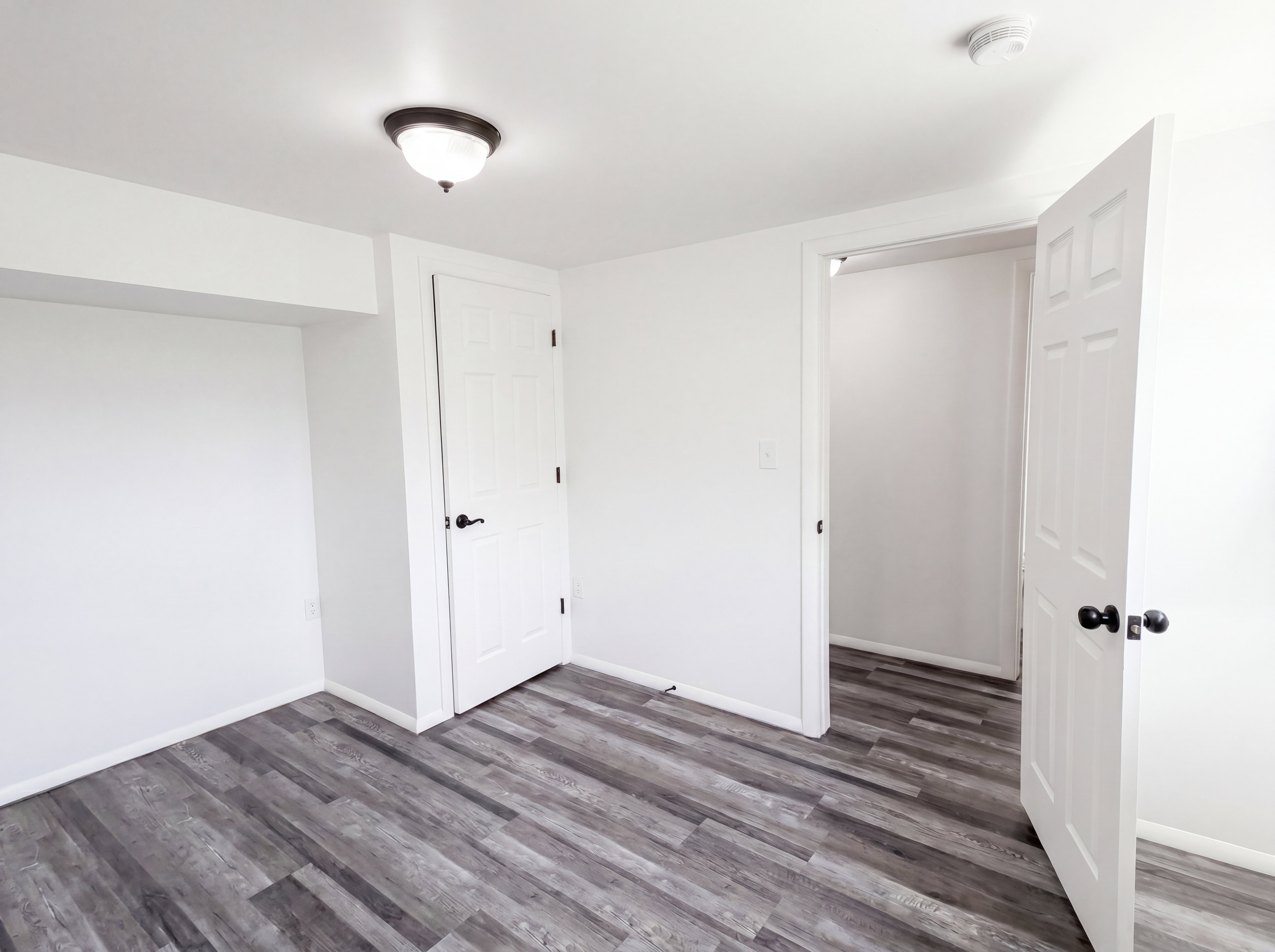 Unfurnished bedroom featuring dark wood-type flooring and baseboards