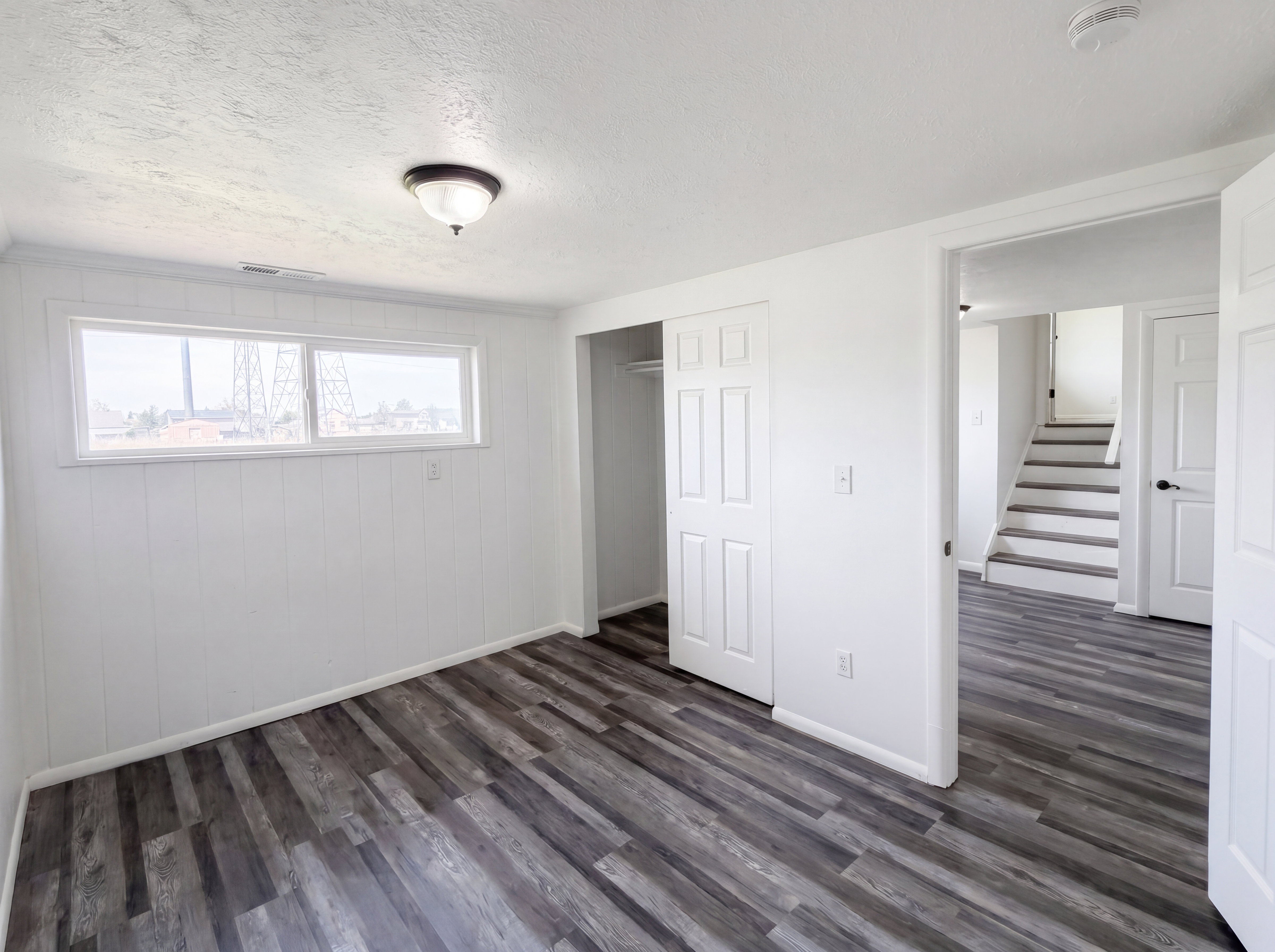 Unfurnished bedroom featuring a textured ceiling, a closet, and dark wood-style floors