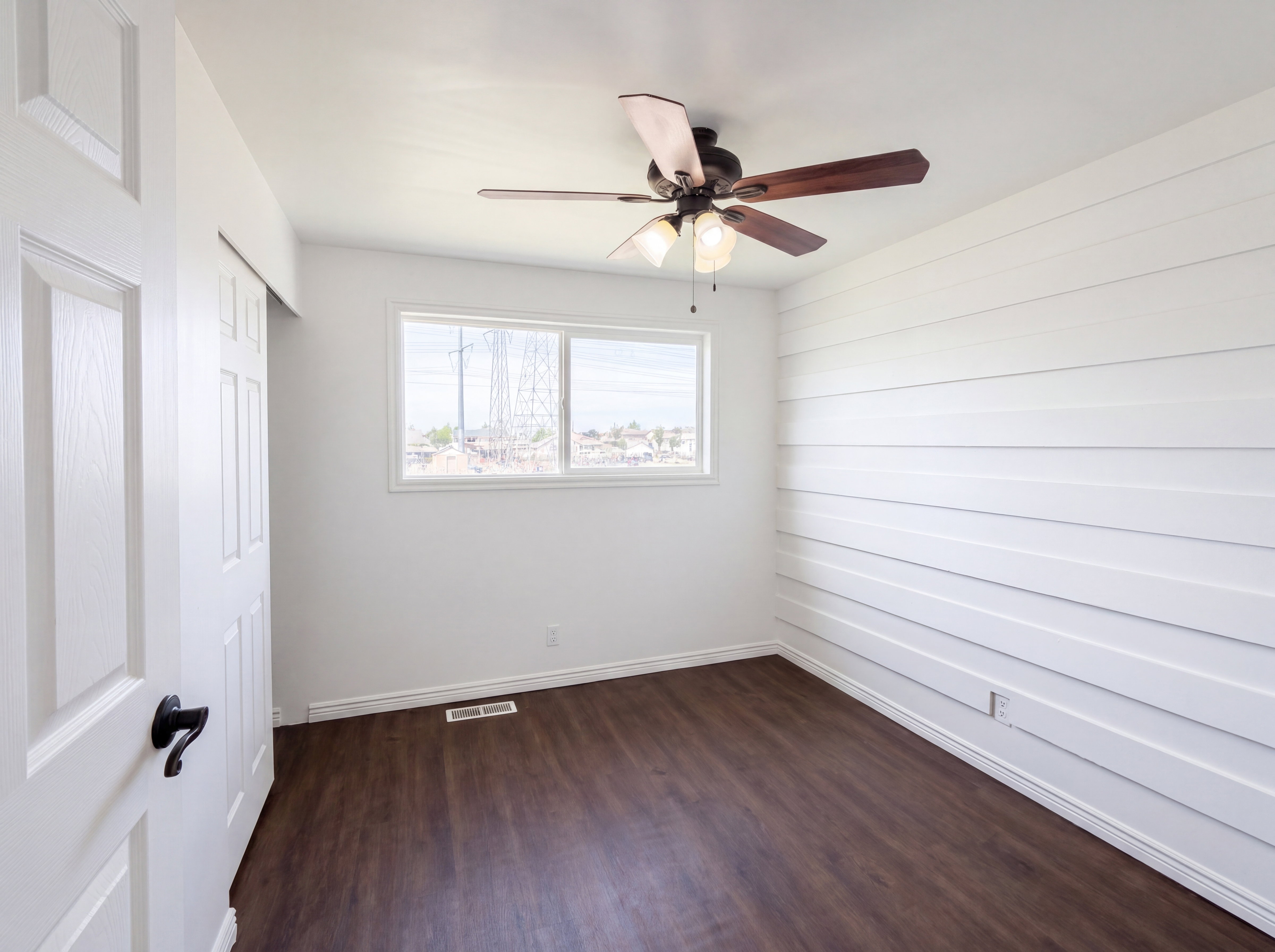 Unfurnished bedroom featuring a closet, dark wood-style floors, and a ceiling fan