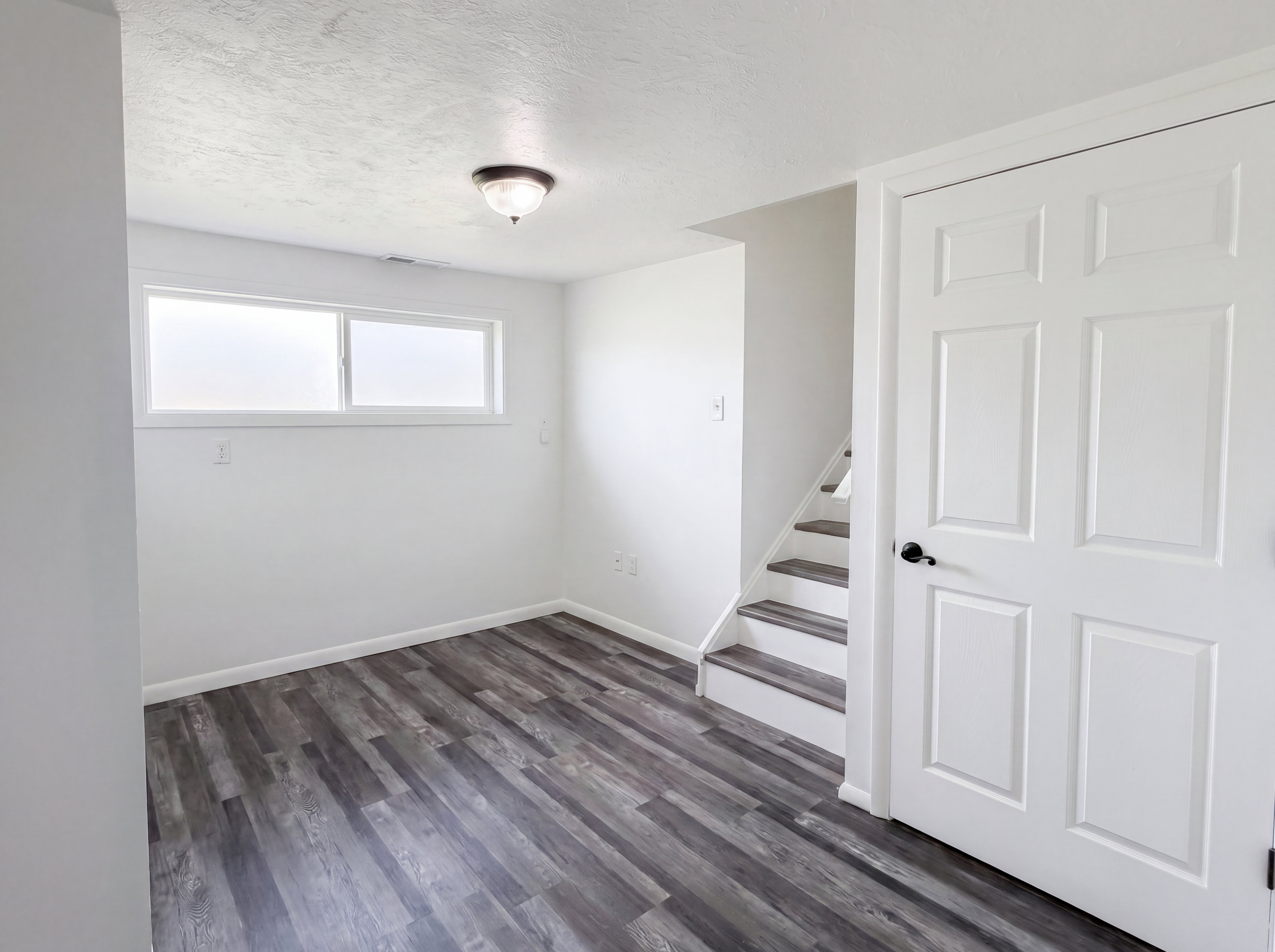 Unfurnished room with dark wood finished floors and a textured ceiling