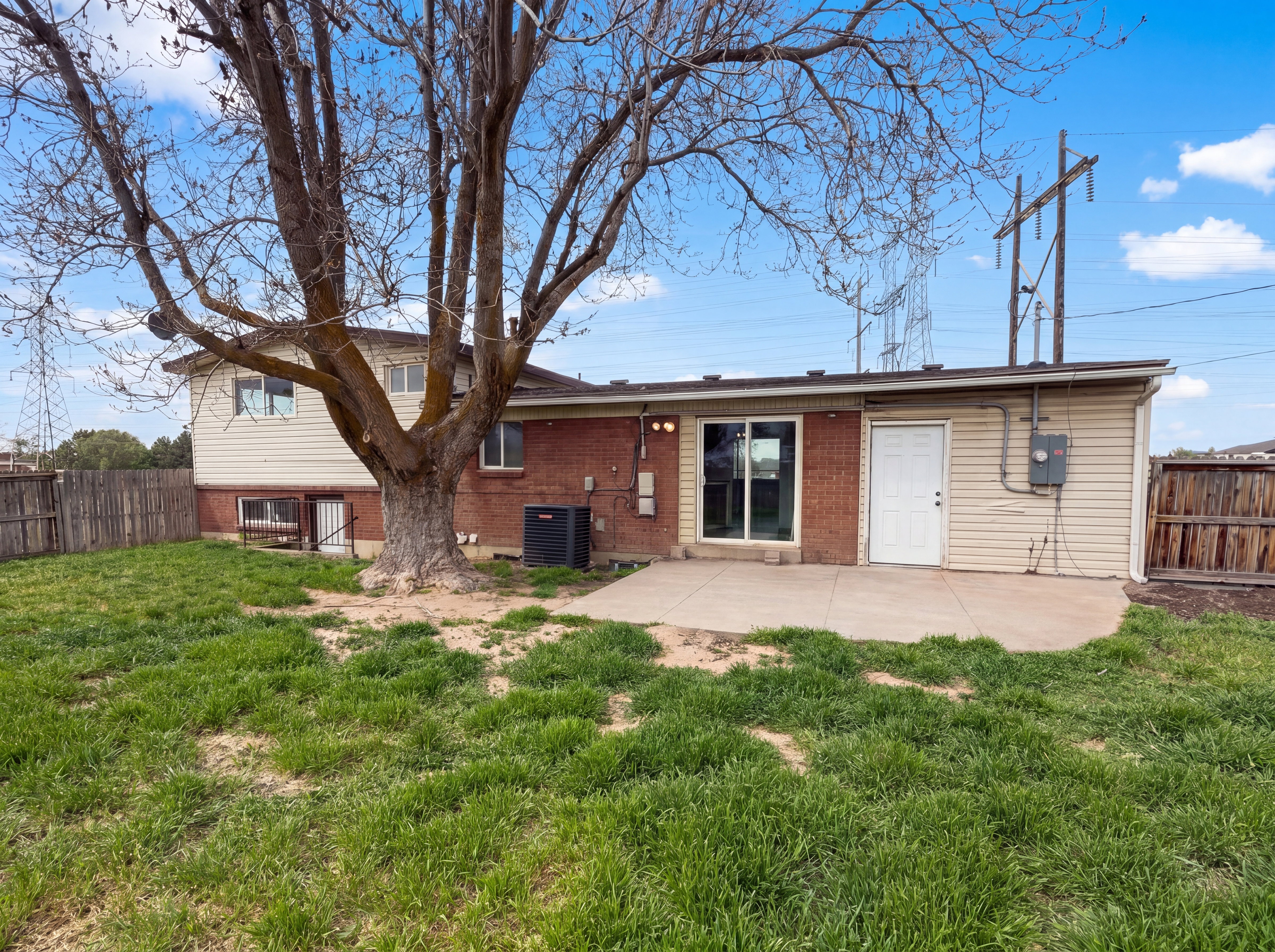 Rear view of property featuring a fenced backyard, a patio, and brick siding