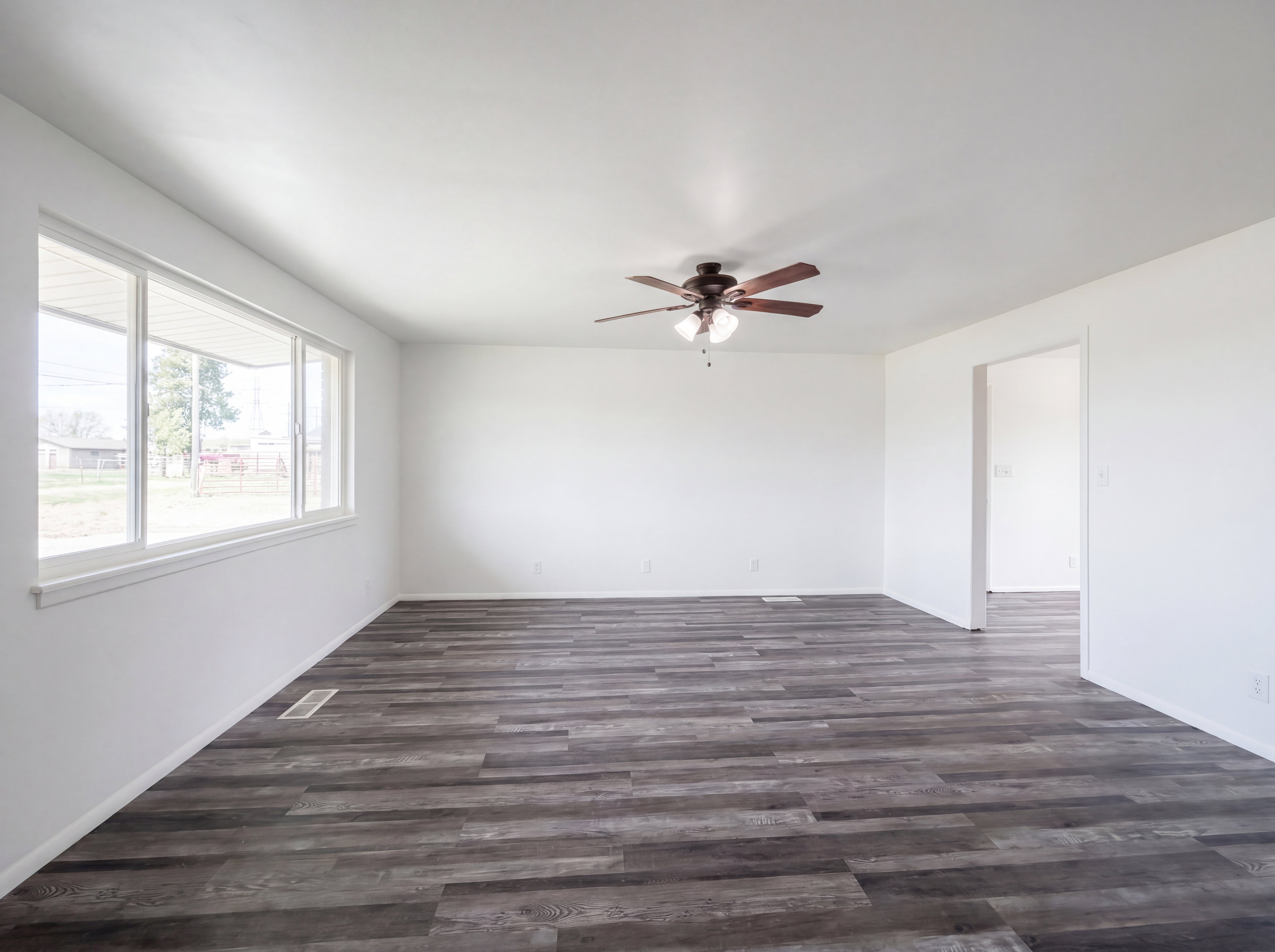 Unfurnished room featuring a ceiling fan and dark wood-style flooring