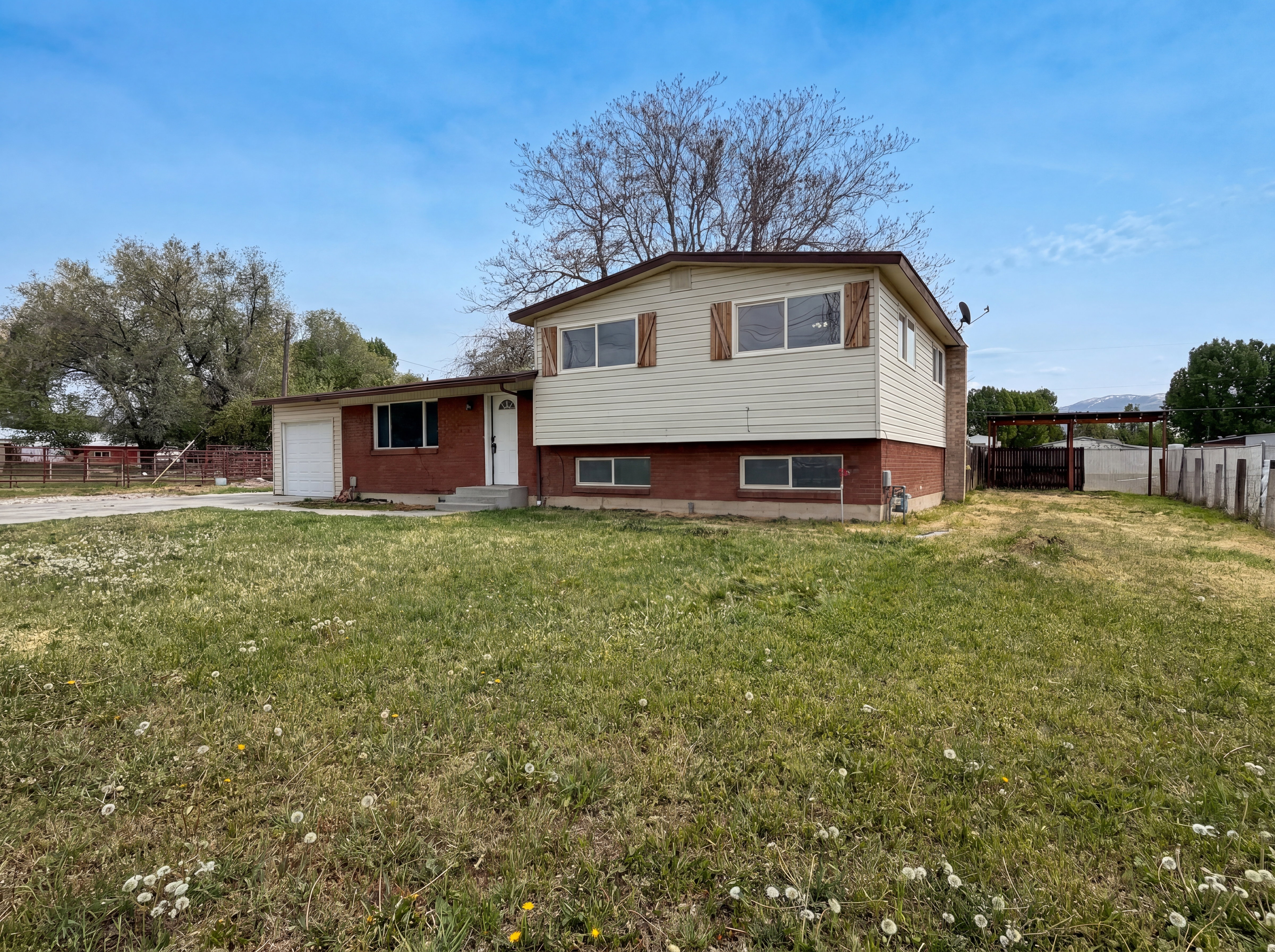 Split level home with an attached garage, brick siding, and concrete driveway