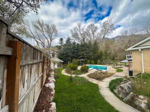 View of grassy yard featuring a patio area and a mountain view