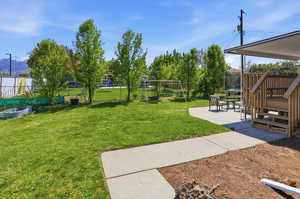 Fenced backyard with a trampoline, a playground, and a patio