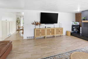 Living room featuring wood finish floors and a textured ceiling