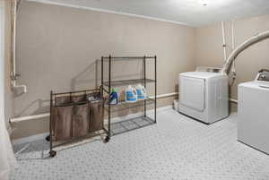 Laundry area with separate washer and dryer and a textured wall